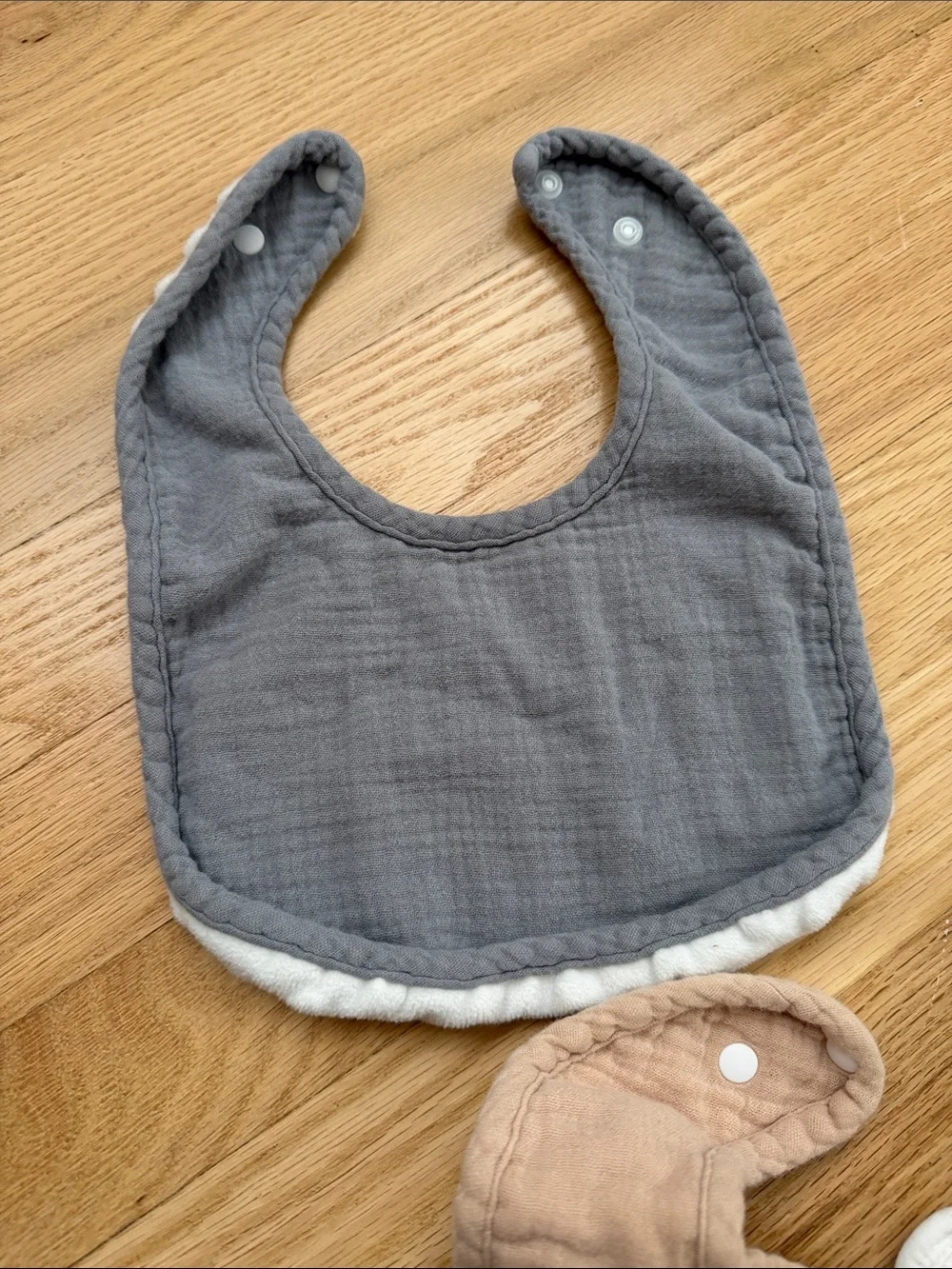 Bundle of muslin baby bibs in earthy colors
